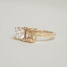 an engagement ring with three stones on the side, in yellow gold plated silver