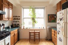 a kitchen with wooden cabinets and green counter tops next to a white refrigerator freezer