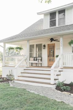 a white house with steps leading up to the front door