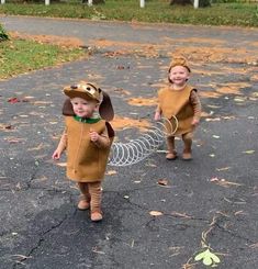 two young children dressed in costumes walking down the street