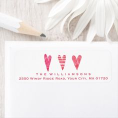 two hearts are drawn on the back of a white envelope with a pencil next to it