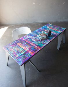 a colorful table with two white chairs next to it