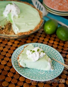 a slice of key lime pie on a blue and white plate next to another pie