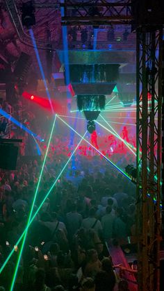 a large group of people in a room with laser lights