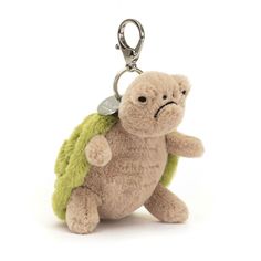 a small stuffed turtle with a keychain attached to it's back, on a white background