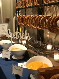 a table topped with lots of donuts and bowls filled with soup next to each other