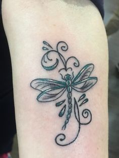 a small dragonfly tattoo on the arm