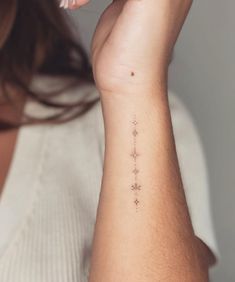 a woman's arm with a small star tattoo on the left side of her wrist