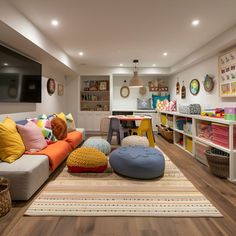 a living room filled with lots of furniture and colorful pillows on top of a rug