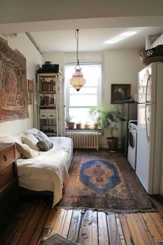 a living room filled with furniture and a rug on top of a hard wood floor