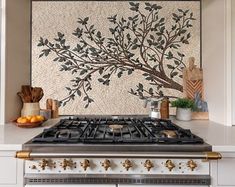 a stove top oven sitting inside of a kitchen next to a painting on the wall