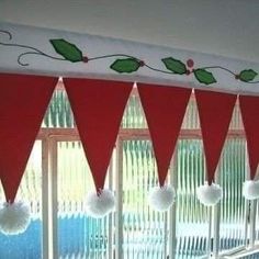 christmas decorations are hanging on the window sill in front of red drapes with white pom - poms