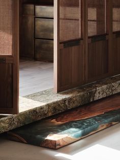 a kitchen counter top sitting next to a wooden cabinet with doors open in front of it