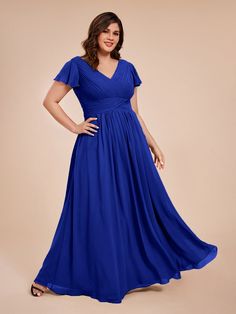 a woman in a blue dress posing for the camera with her hands on her hips