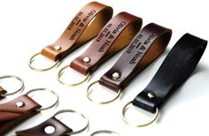 four leather keychains with metal rings on them