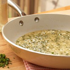 a pan filled with soup sitting on top of a wooden table