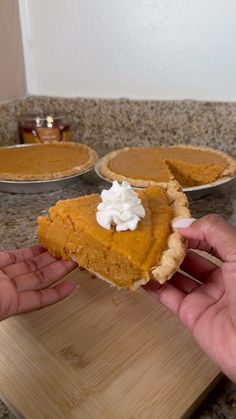 a hand holding a slice of pumpkin pie