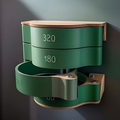 a green wall mounted shelf next to a gray wall with numbers on the top and bottom