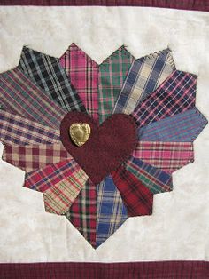 a quilted heart with many different colors and patterns on it's center piece