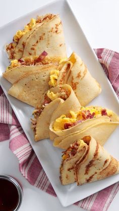 breakfast burritos with eggs and bacon on a white plate