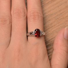 It is a natural garnet ring. The main stone is 7mm*9mm oval cut, weight about 2.33 carats. The basic metal is sterling silver and plated with rhodium. To change the metal to a solid gold (white/rose) or platinum is also available, please ask for a quotation if you want. You can also go to my shop Home for more elegant rings: https://www.etsy.com/shop/godjewelry?ref=hdr_shop_menu More rings: https://www.etsy.com/shop/godjewelry?ref=l2-shop-header-avatar Customization is always welcome and please Oval Cabochon Garnet Jewelry For Anniversary, Anniversary Garnet Oval Cabochon Jewelry, Silver Oval Garnet Birthstone Ring, Oval Garnet Birthstone Ring In Silver, Oval Silver Garnet Birthstone Ring, Oval Garnet Birthstone Ring For Anniversary, Oval Garnet Ring In Silver, Garnet Wedding Rings, Wedding Promises