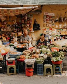 two people are sitting at an outdoor market