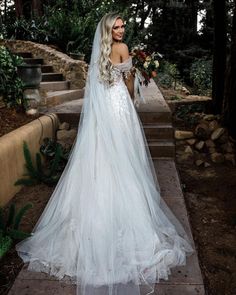 a woman in a wedding dress standing on some steps