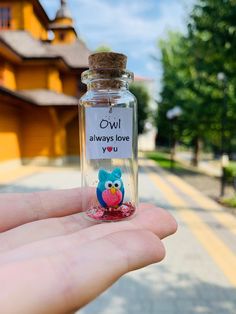 someone is holding up a tiny bottle with an owl on it that says owl always love you