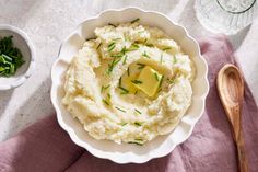 mashed potatoes with butter and green onions in a white bowl