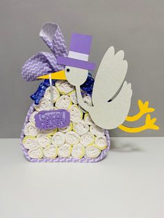 a cake shaped like a stork with a purple hat on it's head