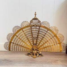 a gold fan sitting on top of a wooden floor