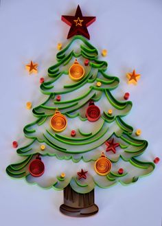 a christmas tree made out of paper on a white surface with red and green decorations