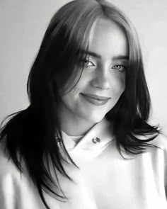 a black and white photo of a woman with long dark hair smiling at the camera