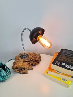 a lamp that is sitting on top of a table next to some books and a vase