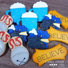 some cookies that are on top of a wooden table and one is decorated with fondant