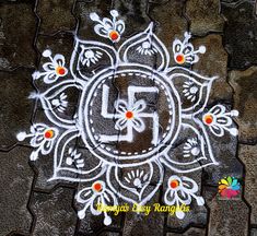 the letter f is written in white chalk on top of a stone floor with flowers and leaves