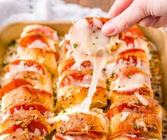 a person dipping cheese on top of a pizza roll with pepperoni and mozzarella