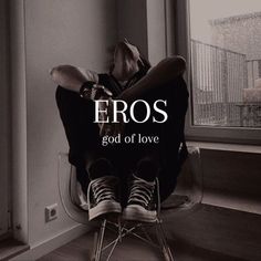 a person sitting on top of a chair next to a window with the words eros god of love