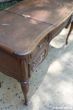 an old wooden desk sitting on the ground