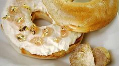 two doughnuts with white frosting and gold sprinkles on a plate