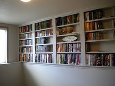 the bookshelves are filled with many different types of books and magazines, along with a clock