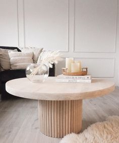 a living room with a couch, coffee table and two candles on top of it