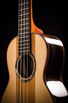 an ukulele is shown against a black background with the strings still attached to it