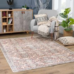 a living room area with a rug, chair and potted plant