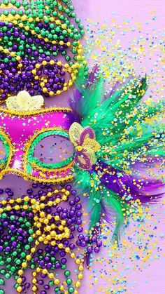 two mardi gras masks with beads on them