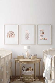 a baby's room with two cribs, a table and pictures on the wall