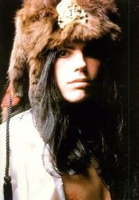 a woman wearing a fur hat with a gold brooch on it's head