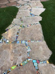 a walkway made out of mosaic tiles in the grass