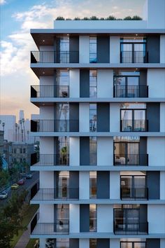 an apartment building with balconies and balconies on the second floor is shown at dusk