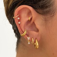 a woman wearing three different types of ear piercings on her left side of the ear